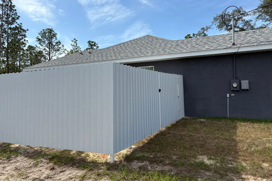 White PVC privacy fence beside a home