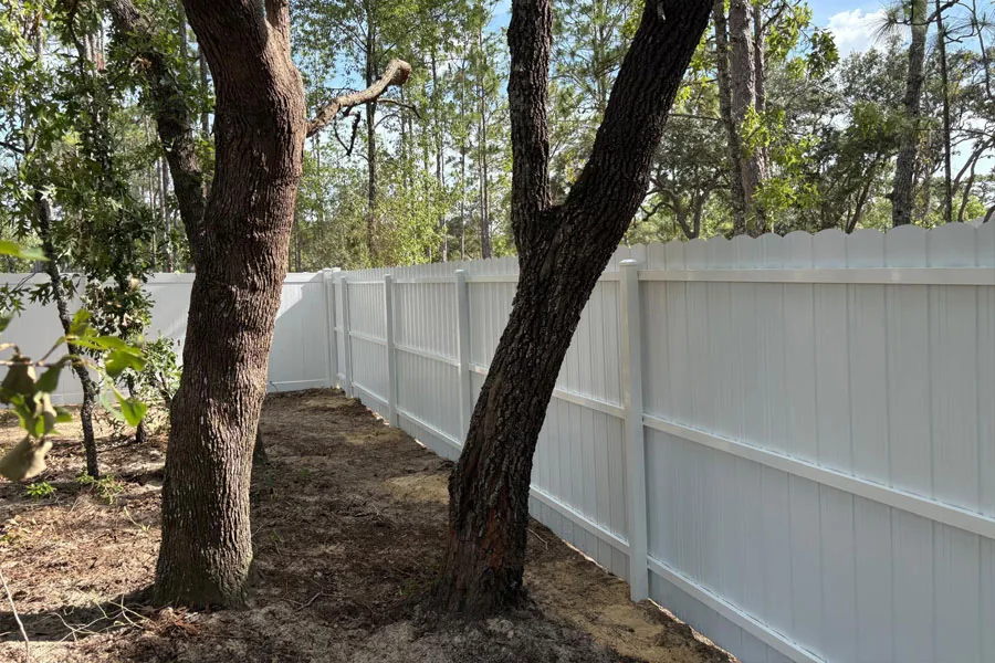 Long white PVC fence line around a yard