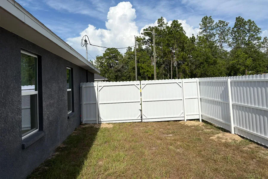 White PVC privacy fence along a house