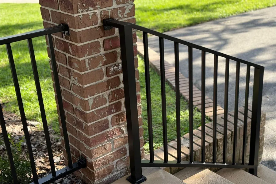 Black metal railing beside exterior brick steps