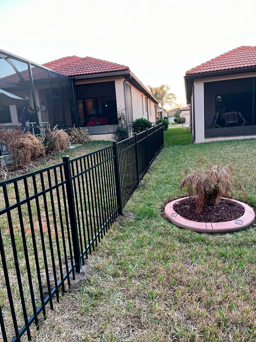 Black aluminum boundary fence in a yard