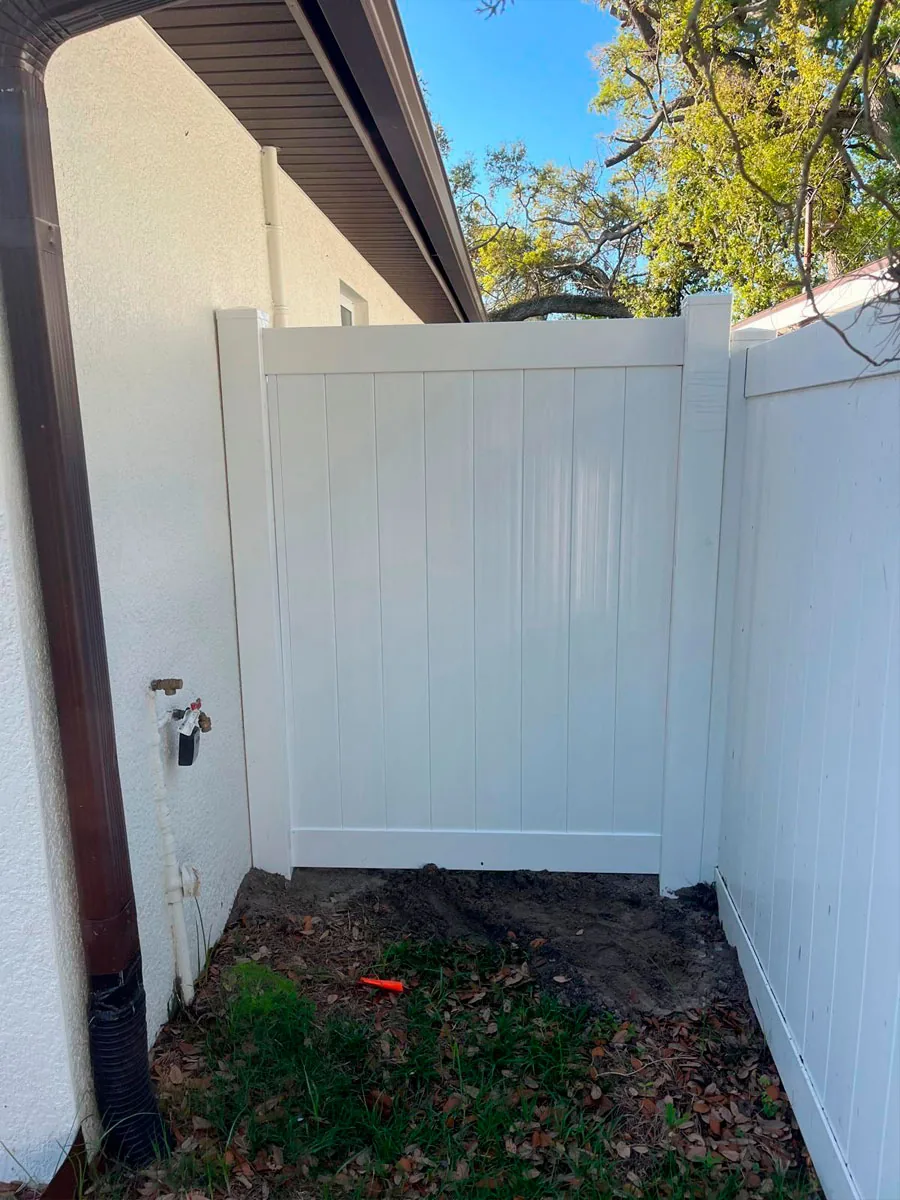 White PVC privacy fence beside a home