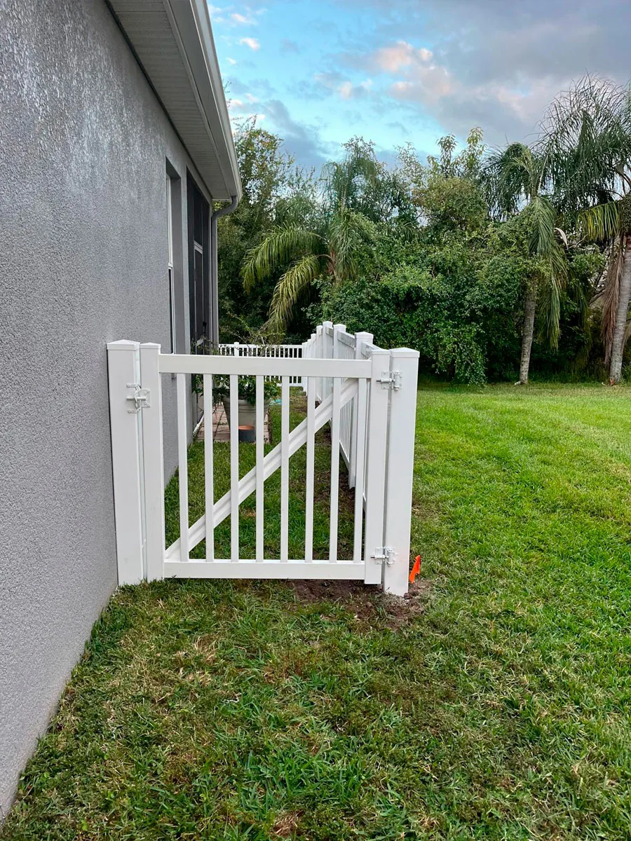 White PVC access gate beside a house