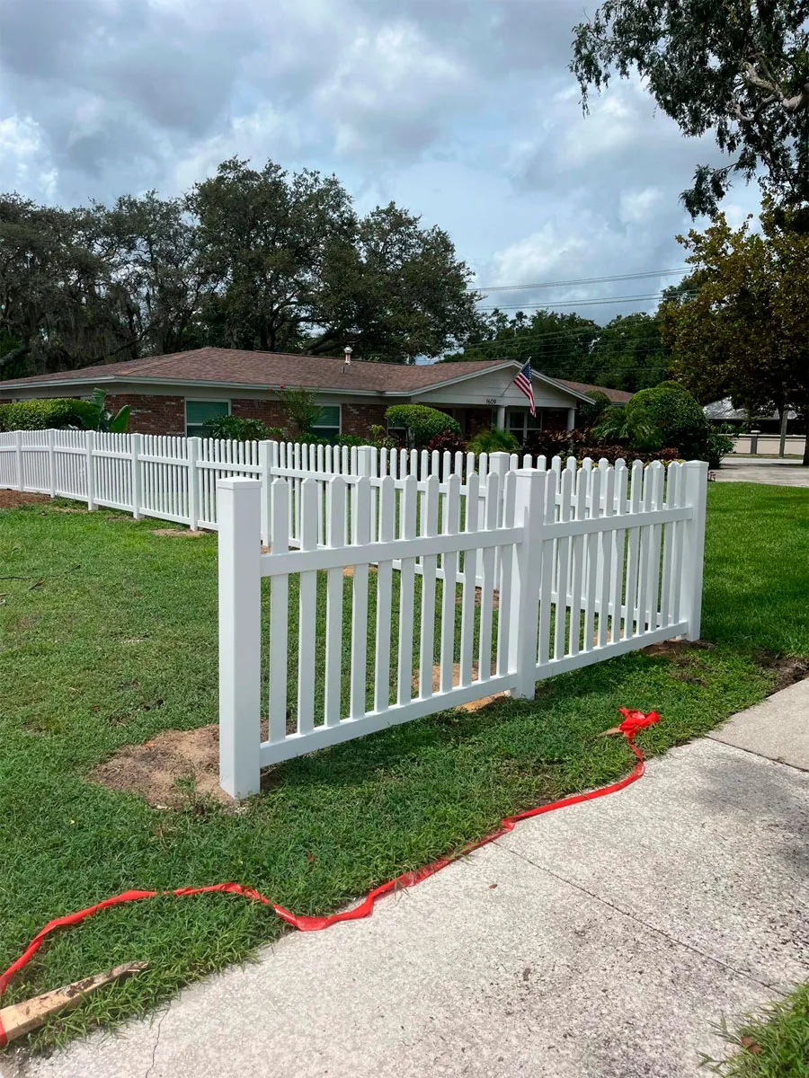 White PVC picket fence at a property corner