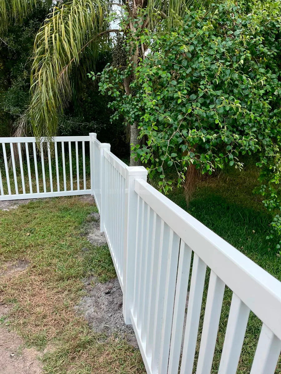White PVC picket fence along a backyard