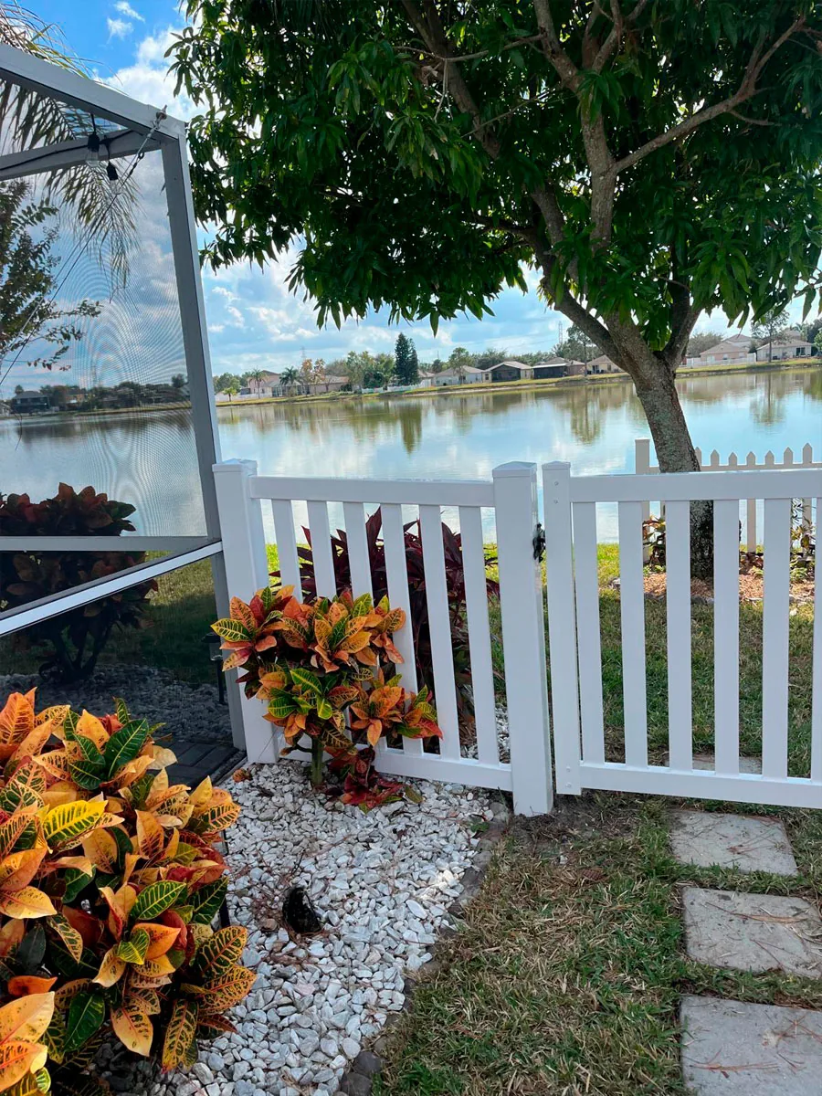 White PVC picket gate at a garden path