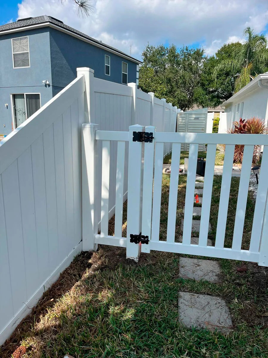 White PVC picket gate along a walkway