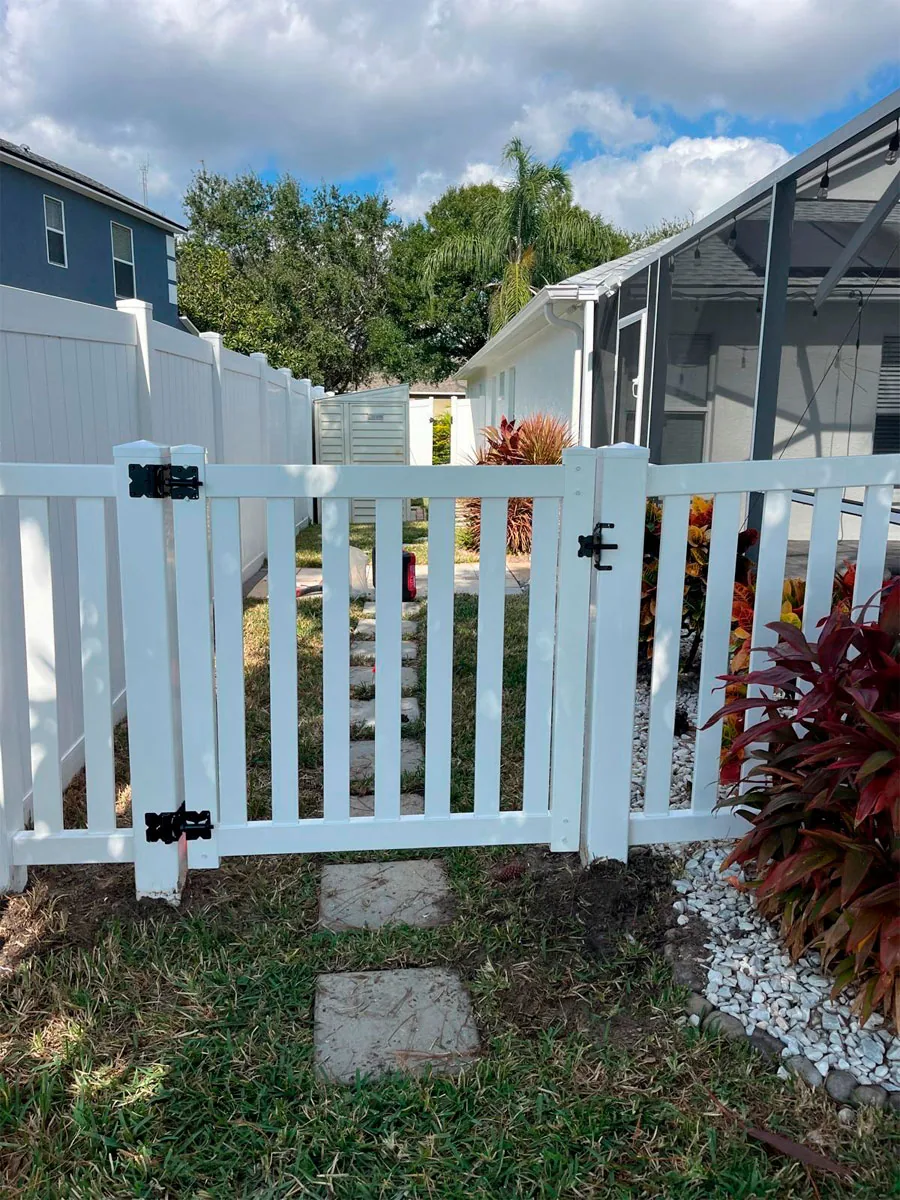 White PVC picket gate at a residential entry