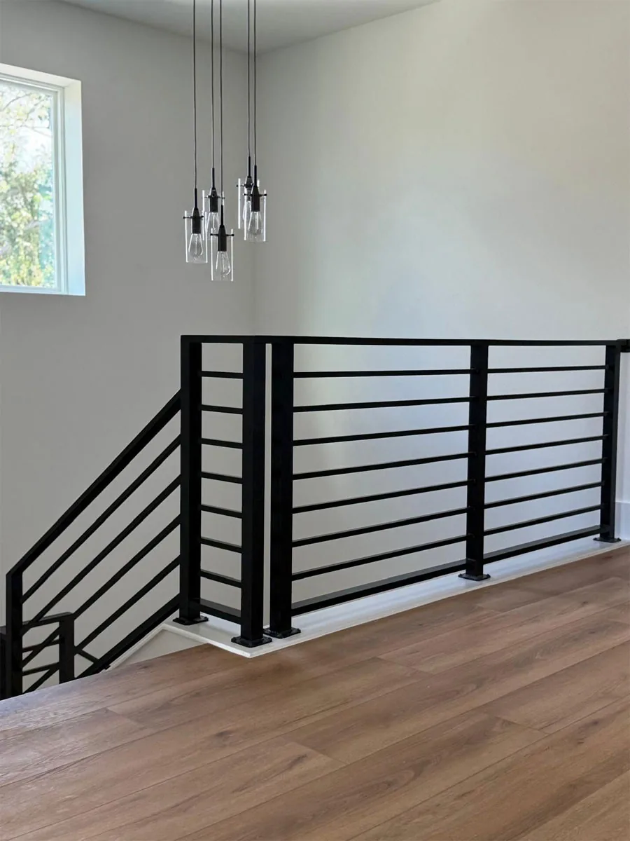 Black horizontal metal railing at an indoor landing