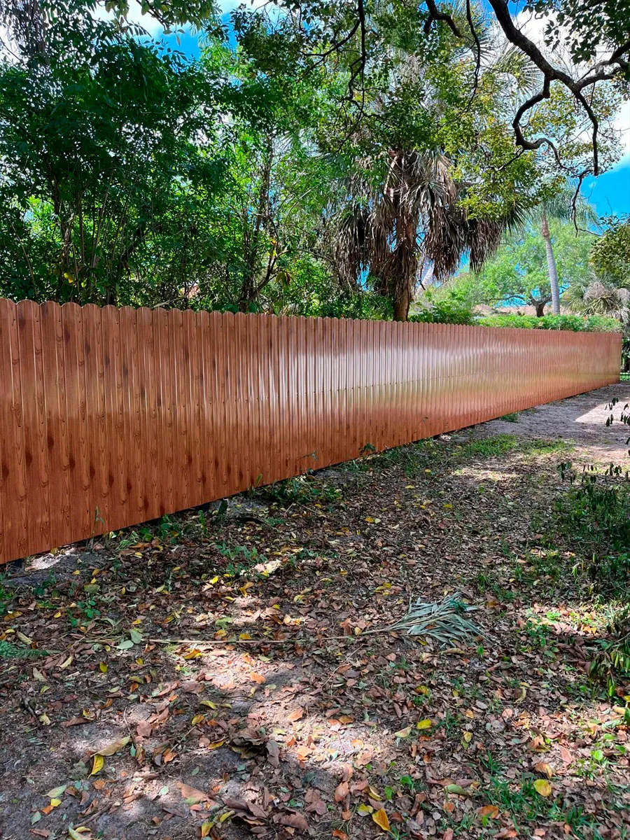 Natural wood privacy fence in a wooded yard