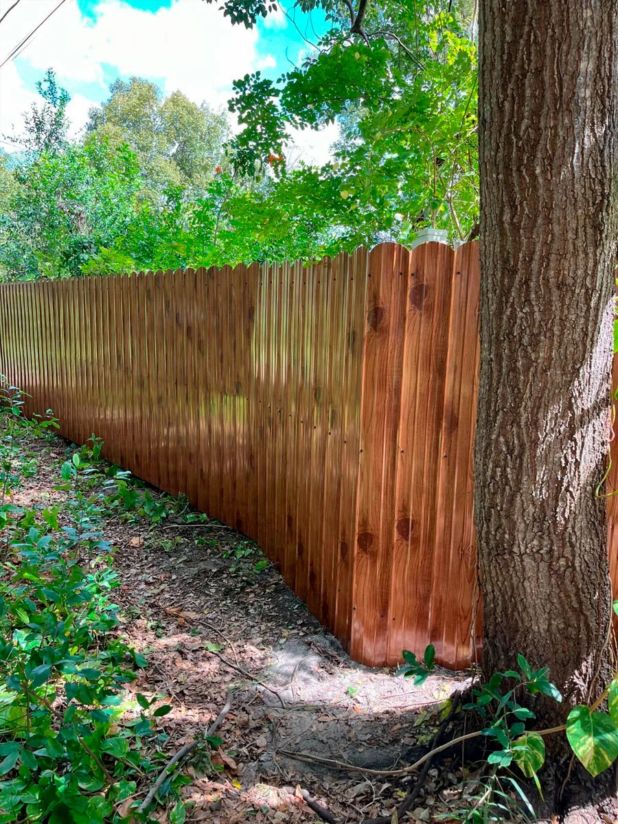 Completed wood privacy fence beside mature trees