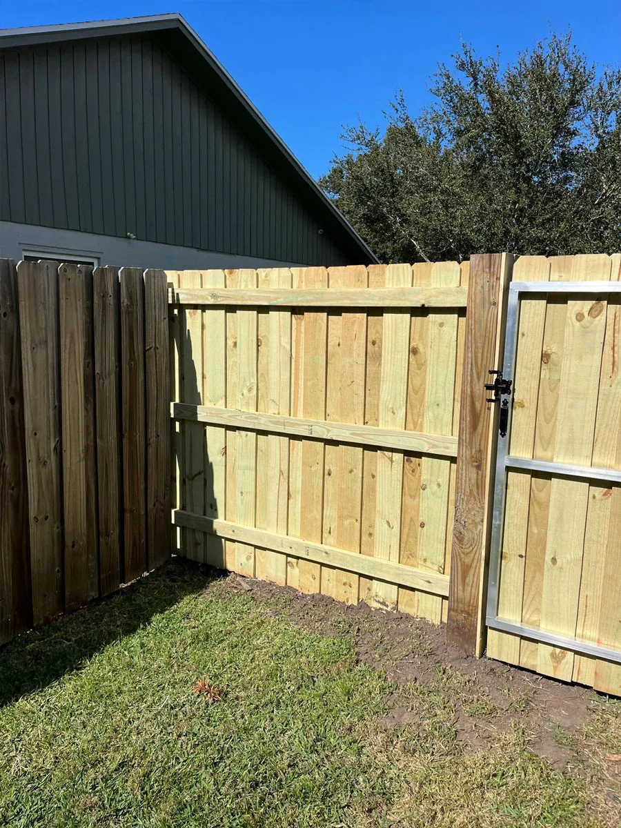 Tall wood privacy gate beside a home