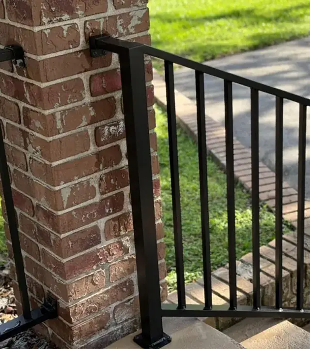 Black metal railing beside exterior brick steps